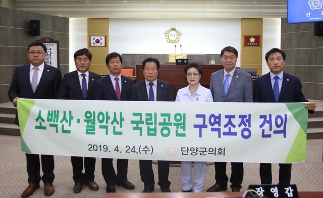 ▲ 24일 김영주 단양군의회 의장(가운데)과 의원들이 본회의장에서 월악·소백산국립공원 구역조정을 요구하는 건의문을 채택하고 있다.ⓒ단양군의회