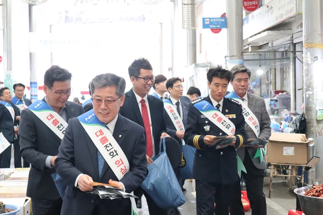 ▲ 도기윤 경북농협 본부장(맨 앞쪽)과 김형률 칠곡경찰서장(오른쪽)이 직원들과 전기통신 금융사기 예방 전단지를 배부하고 있다.ⓒ경북농협