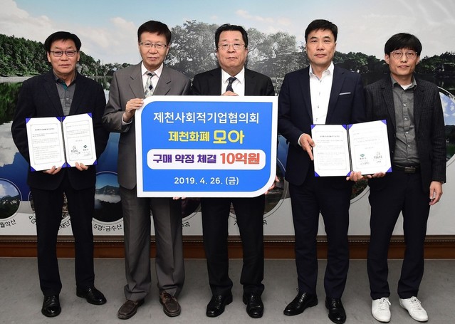 ▲ 신학주 제천사회적기업협의회장(왼쪽 두번째)이 지난 26일 이상천 시장과 제천화폐 구입을 약속하는 협약을 체결하고 있다.ⓒ제천시