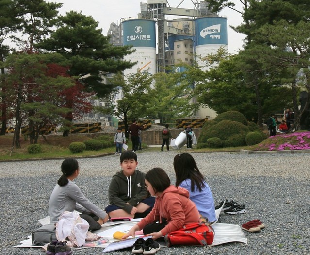 ▲ 매화골 봄맞이 어린이 그림그리기 대회에 참가한 학생들이 한일시멘트 공장 내 우덕원에서 공장을 배경으로 그림을 그리고 있다.ⓒ한일시멘트 제공