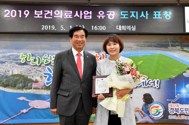 ▲ 도지사 표창을 받는 박선영 씨(오른쪽)가 최영조 경산시장으로 부터 표창을 받고 기념촬영을 하고 있다.ⓒ경산시