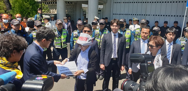 ▲ 2일 오전 청와대 춘추관 앞에서 청와대 사회정책비서관실 소속 행정관(왼쪽)이 전국장애인부모연대 주최 측 관계자를 만나 대통령 면담 요구서를 접수하고 사진을 촬영에 임하고 있다. ⓒ전성무 기자