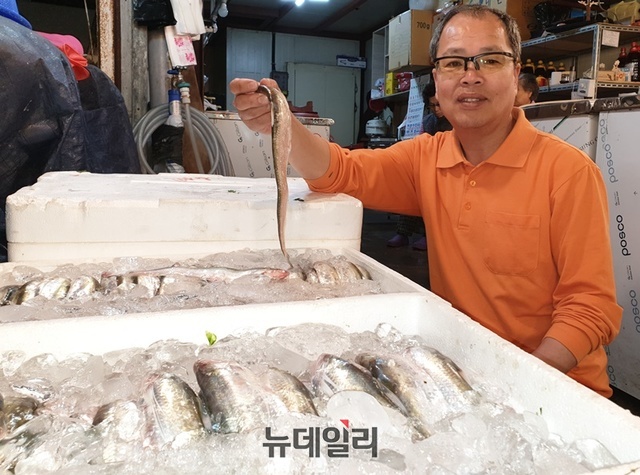 새마을젓갈상회 김수철씨가 생선을 들어보이며 설명하고 있다.ⓒ박근주 기자