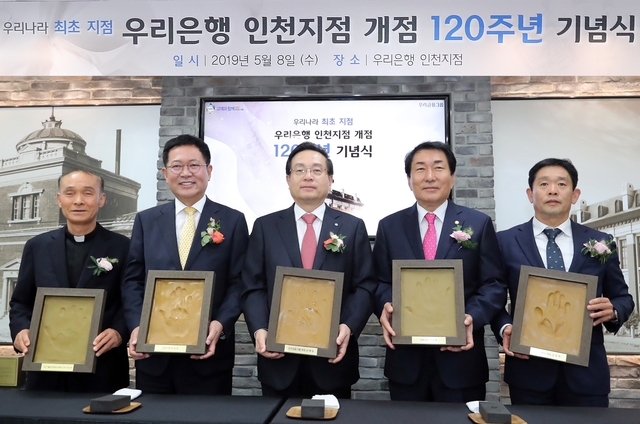 ▲ 지난 8일 우리은행 ‘인천지점 개점 120주년 기념행사’에 참석한 주요인사들이 인천지점의 새로운 출발과 힘찬 도약을 다짐하는 의미에서 본인의 핸드프린팅을 들고 기념사진을 촬영하고 있다. 왼쪽부터 이용권 카톨릭아동청소년재단 이사장(신부), 박남춘 인천시장, 손태승 우리금융 회장 겸 우리은행장, 안상수 국회의원, 김영제 NKG 대표이사. ⓒ우리은행