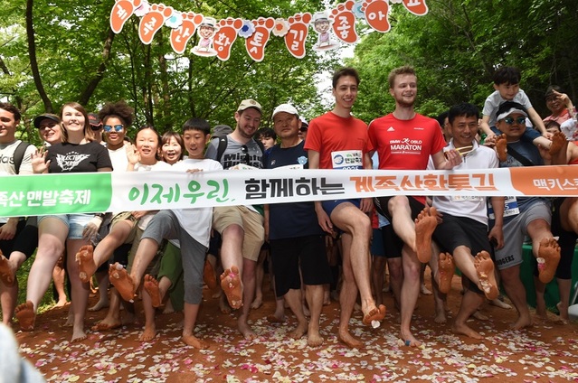 ▲ 대전 향토기업 맥키스 컴퍼니가 개최한 2019 계족산 맨발축제가 12일 계족산에서 열린 가운데 참가자들이 출발하기 전에 황토가 묻은 맨발을 보여주고 있다.ⓒ맥키스 컴퍼니