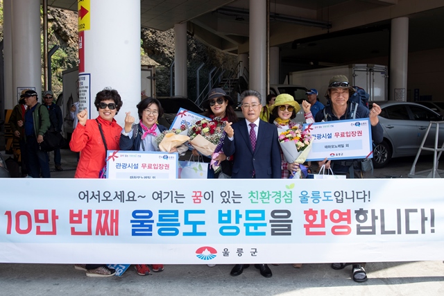 ▲ 김병수 울릉군수는 울릉도 관광객 10만 명 돌파 기념 행사를 개최하고 10만 번째 관광객에게 특산품 및 꽃다발 등을 증정했다.ⓒ울릉군