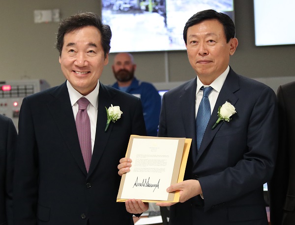 ▲ 신동빈 롯데 회장(오른쪽)과 이낙연 국무총리가 지난 9일 미국 루이지애나주 에탄크래커 공장 준공식에서 도널드 트럼프 미국 대통령의 축하메시지를 들고 기념사진을 찍고 있다. ⓒ연합뉴스