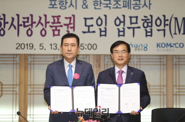 ▲ 이강덕 포항시장(사진 왼쪽)과 조용만 한국조폐공사 사장(오른쪽)이 모바일 포항사랑상품권 업무 협약서를 들고 기념촬영을 하고 있다.ⓒ뉴데일리