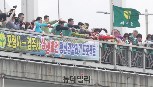 ▲ 형산큰다리에서 이강덕 포항시장과 주낙영 경주시장을 비롯한 새마을회 관계자들이 형산강 정화를 위해 EM액 및 EM흙공을 뿌리고 있다.ⓒ뉴데일리