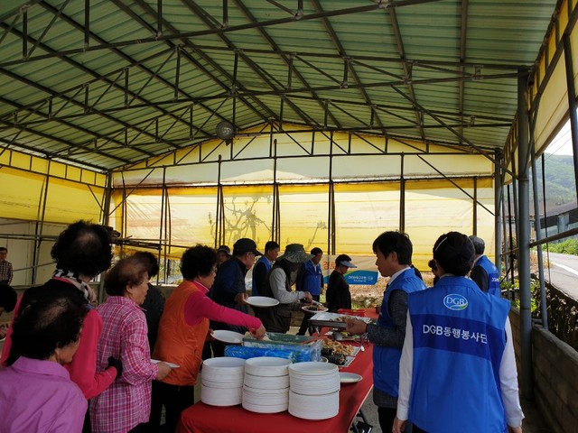 ▲ 지난 8일 어버이날을 맞아 자매결연마을인 경산시 용성면 용전리 마을회관에서 열린 행사에는 봉사단원 10여명이 나서 마을 어르신 70여명에게 사랑의 밥상을 전달했다.ⓒ대구은행