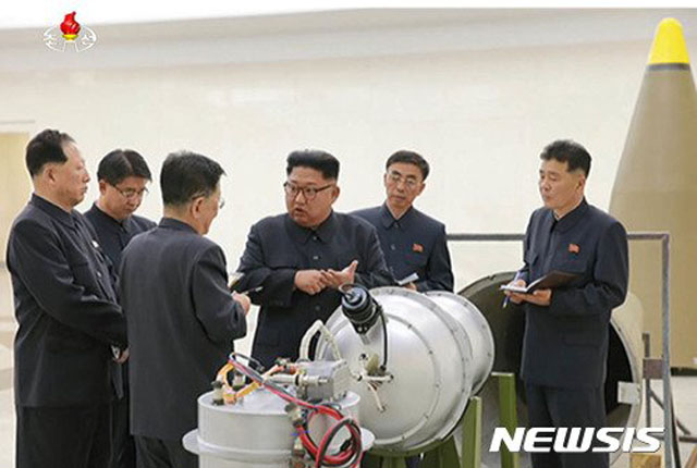 ▲ 2017년 9월 핵무기 연구소를 찾은 김정은이 '화성-14형' 미사일에 장착하는 핵탄두에 대해 이야기를 나누고 있다. ⓒ뉴시스. 무단전재 및 재배포 금지.