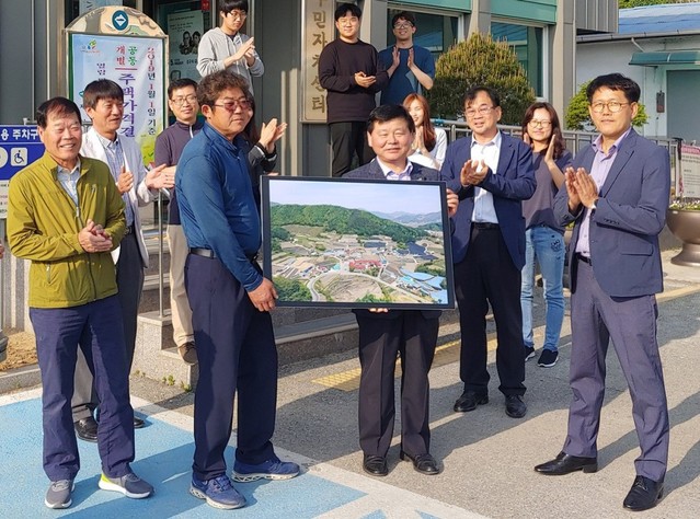 ▲ 이영희 제천시 국장(오른쪽 두번째)이 17일 백운면사무소에서 백운 원월2지구 지적재조사를 마치고 사업지구를 항공촬영한 사진을 주민 대표에게 전달하고 있다.ⓒ제천시