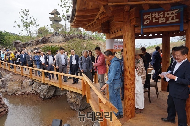 ▲ 상상나라 제주 탐나라공화국 개국이 건설 6년 만에 17일 이뤄졌다. 이날 영천 나무로 만든 영천다리에서 강우현 대표와 최기문 영천시장과 관계자 등이 참석한 가운데 다리를 건너고 있다. 강우현 대표가 영천 은하수 길에 대해 설명을 하고 있다.ⓒ김정원 기자