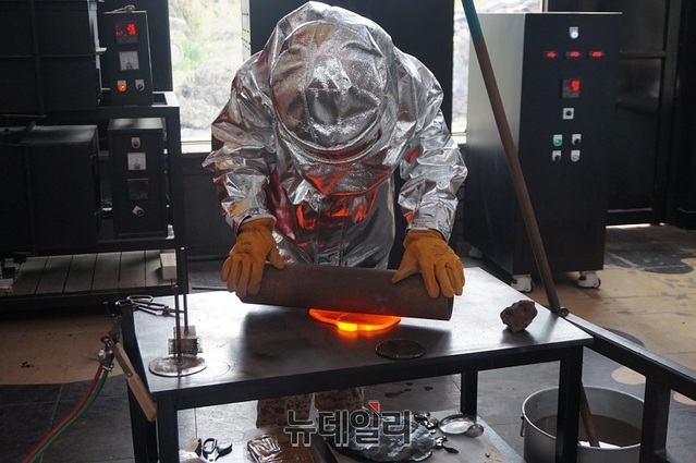 ▲ 제주 탐나라 공화국 용광로에서 녹아 있는 돌(1500도)을 꺼내 작품(라바스톤)을 만들고 있다.ⓒ김정원 기자