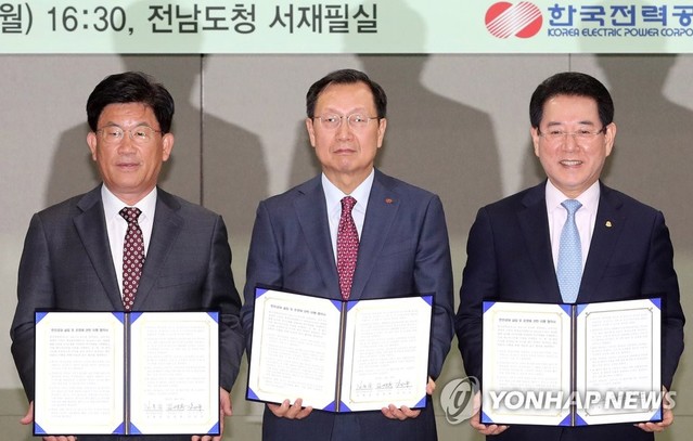 ▲ 김종갑 한국전력공사 사장(가운데)이 지난달 29일 한전공대 설립과 운영 이행협약식에서 굳은표정으로 기념사진을 촬영하는 모습. 김사장 오른쪽이 김영록 전남지사, 왼쪽이 강인규 나주시장. ⓒ연합뉴스