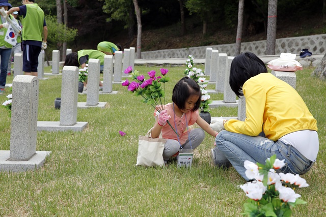 ▲ 봉사활동에 참여한 현대엔지니어링 임직원과 가족이 묘역을 단장하고 있다. ⓒ현대엔지니어링