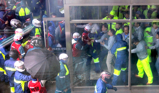 ▲ 현대중공업 울산 본사 본관 출입문에서 지난 27일 헬멧을 쓴 노조 조합원들이 강제로 건물에 들어가려다 막아서는 직원들과 몸싸움을 벌이고 있다. ⓒ연합뉴스