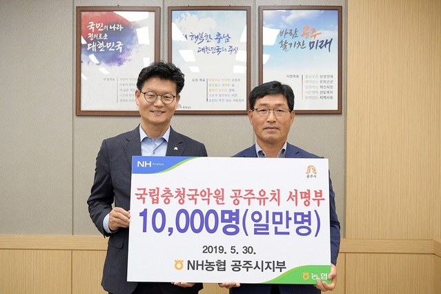 ▲ 차재희 농협공주시지부장(오른쪽)이 지난달 30일 김정섭 공주시장에게 1만명 서명부를 전달하고 있다.ⓒ농협공주시지부