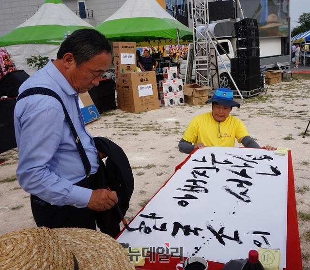 강우현 제주 탐나라공화국 대표가 지난 1일 충남 서산 축협육산한마당 축제에 참석, 서산소는 한국소의 아버지라는 글을 붓으로 쓰고 있다. ⓒ김정원 기자