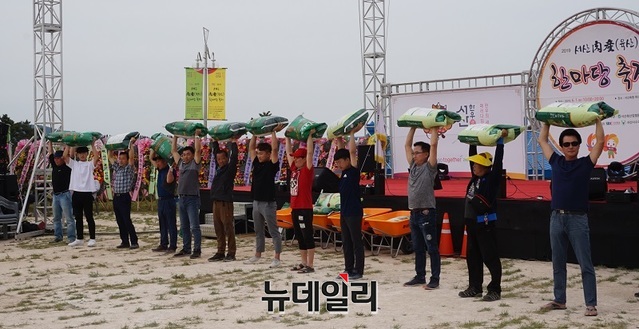 ▲ 축산농민들이 지난 1일‘2019 서산 육산(肉産)한마당 축제’ 에서 사료포 오래들기 게임을 하고 있다.ⓒ김정원 기자