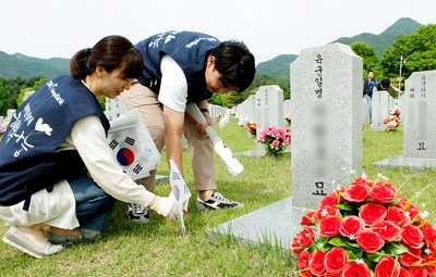 ▲ 지난 1일 OK저축은행 직원들이 국립대전현충원서 태극기 꽂기, 헌화, 묘비닦기 등 묘역정화 봉사활동을 펼쳤다.ⓒOK저축은행