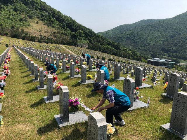 ▲ 한국원자력환경공단 청정누리봉사단원들이 영천 호국원 묘역에서 정화활동을 하고 있다.ⓒ방폐장