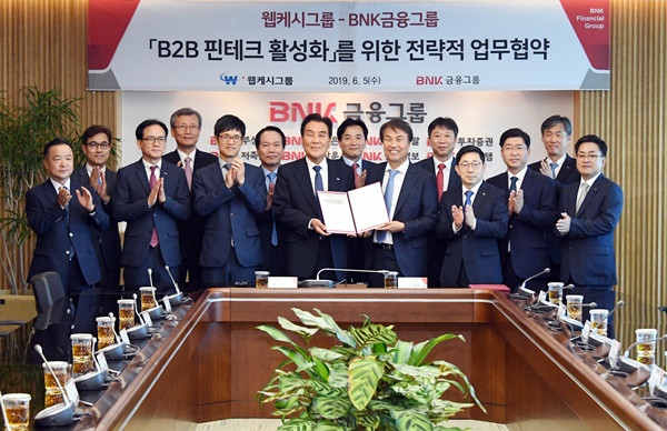 ▲ 김지완 BNK금융그룹 회장(왼쪽 네번째)이 지난 5일 석창규 웹케시그룹 회장(오른쪽 네번째) 및 관계자들과 ‘B2B 핀테크 활성화를 위한 전략적 업무협약’을 체결한 후 기념촬영을 하고 있다. ⓒBNK금융그룹