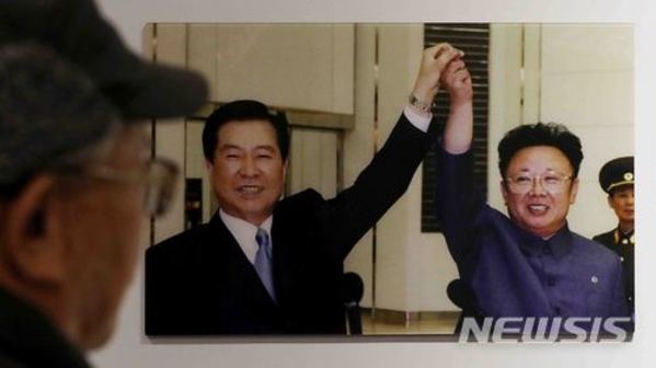 ▲ 지난 2000년 남북정상회담 사진을 한 관람객이 살펴보고 있다ⓒ뉴시스.