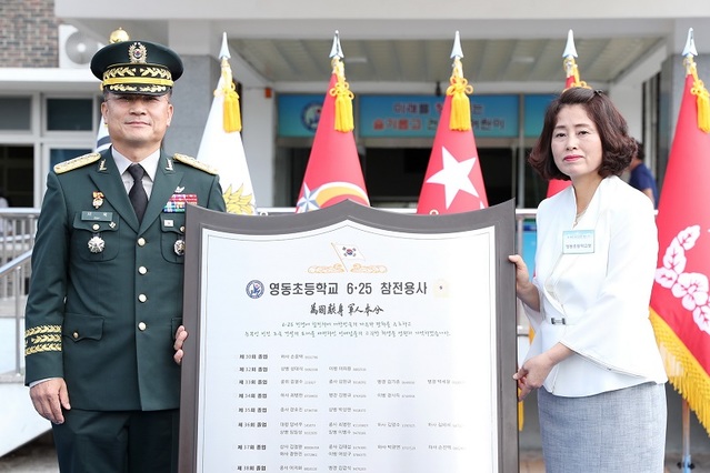 ▲ 서훈 육군참모총장이 17일 영동초등학교에서 27명의 6·25 참전용사 이름이 새겨진 명패를 김종숙 영동초등학교 교장에게 전달하고 있다.ⓒ육군본부