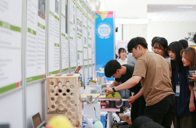 ▲ 지난 12일 대구가톨릭대 대강당에서 열린 1학기 ‘캡스톤 디자인 전시 및 경진대회’에 참가한 학생들이 전시된 시제품을 살펴보고 있다.ⓒ대가대