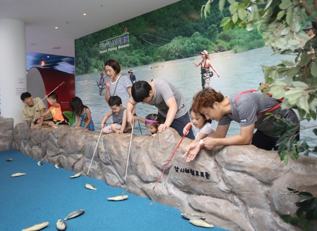 ▲ 단양다누리아쿠아리움을 찾은 가족단위 관람객들이 낚시박물관에서 시뮬레이션을 통해 장난감 고기를 낚는 체험을 하고 있다.ⓒ단양군