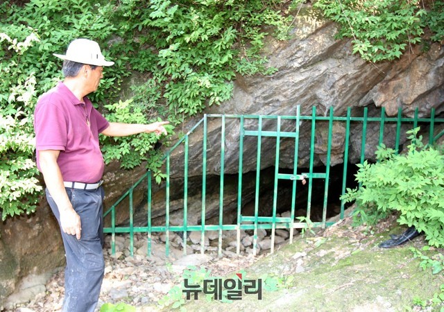 ▲ 조병규 단양곡계굴희생자대책위원장이 한국전쟁 당시 가족들과 마을주민들이 몸을 피하기 위해 들어가 생활했던 곡계굴을 가르키고 있다.ⓒ목성균 기자