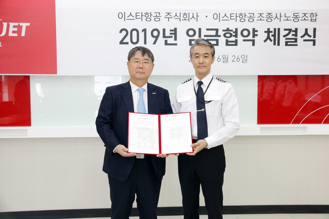 ▲ 26일 서울 강서구 이스타항공 대회의실에서 열린 2019 임금협약 체결식에서 이스타항공 최종구 대표이사(왼쪽)와 신영근 조종사노동조합 위원장(오른쪽)이 서명식을 갖고 기념촬영을 하고 있다ⓒ이스타항공