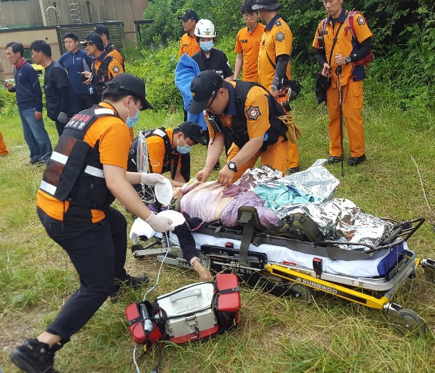 ▲ 27일 제천소방서 구급대원들이 실종 5일 만에 찾은 할머니에게 병원 이송 전, 응급처치를 하고 있다.ⓒ제천소방서