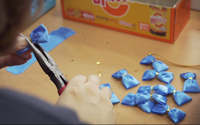 ▲ 영화 '파란나비 효과' 가운데 파란리본으로 나비를 만드는 모습. ⓒ영화 '파란나비 효과' 캡쳐