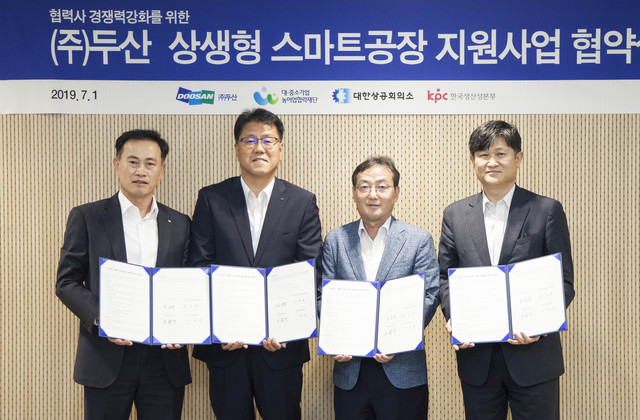 ▲ 1일 서울 동대문 두산타워에서 열린 ‘㈜두산 상생형 스마트공장 지원사업’ 협약식의 참석자들이 협약서를 들고 기념촬영을 하고 있다. (사진 왼쪽부터) 노금기 대한상공회의소 상무, 민은식 ㈜두산 커뮤니케이션 상무, 고근모 대중소기업농어업협력재단 본부장, 이규현 한국생산성본부 본부장ⓒ㈜두산
