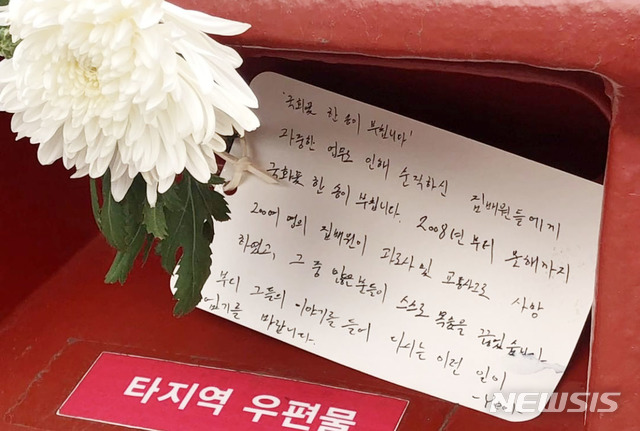 ▲ 서울 종로구 한 우체국 앞 우체통에 놓인 국화꽃 한 송이와 엽서.ⓒ뉴시스