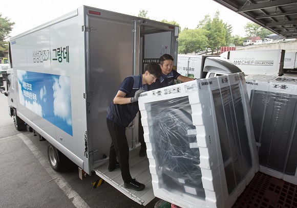 ▲ 삼성전자 제품 배송·설치 담당자들이 17일 경기도 고양시 일산서구에 위치한 삼성전자 서서울물류센터에서 삼성 건조기 그랑데를 배송하기 위해 차량에 싣고 있다.ⓒ삼성전자