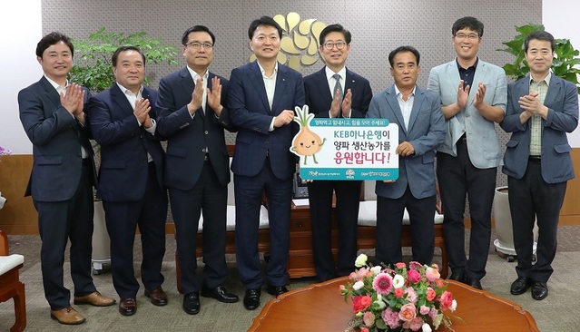 ▲ 민의홍 KEB 하나은행 충청은행 영업그룹대표(왼쪽 4번째)가 18일 충남도청에서 양승조 충남도지사와 양파 재배 농민들이 참석한 가운데 양파 12t을 구매하는 전달식을 갖고 있다.ⓒ충남도