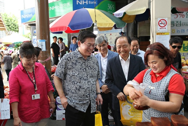 ▲ 자유한국당 정우택 의원이 19일 청주육거리시장에서 공유가치창출 행사를 가진뒤 물건을 구입하고 있다.ⓒ정우택 의원실