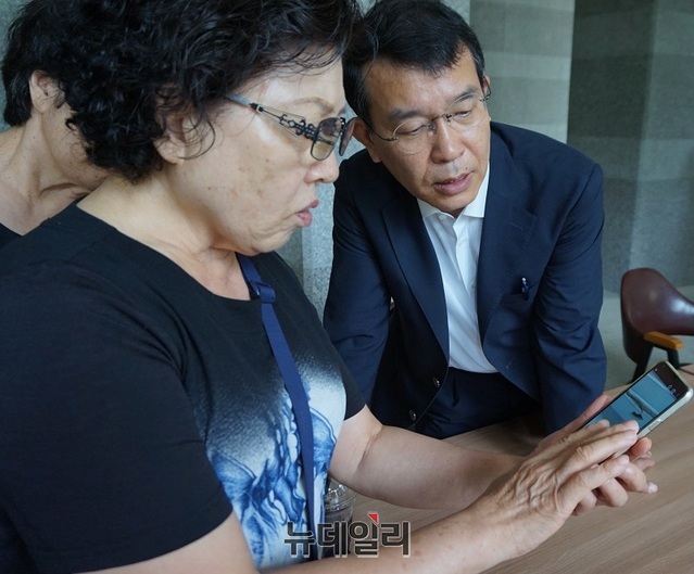 ▲ 정의당 김종대 의원이 20일 충북 청주시 상당구 중흥S클래스 아파트에서 입주민들과 아파트 하자 처리 문제를 놓고 대화를 가졌다. 김 의원이 한 입주민이 휴대폰에 저장된 아파트 창틀하자 사진을 보여주자 자세히 살펴보고 있다.ⓒ김정원 기자