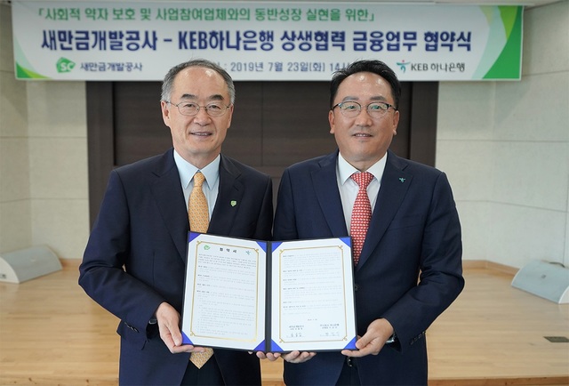 ▲ KEB하나은행이 23일 전북 군산시에 위치한 새만금개발공사 본사에서 새만금개발공사와 '상생협력을 위한 금융지원' 업무협약을 체결하고 새만금개발사업 참여기업을 위한 상생펀드 조성과 금융지원을 약속했다. 정민식 KEB하나은행 호남영업그룹장(오른쪽)과 김금남 새만금개발공사 혁신경영본부장이 협약서를 들고 기념촬영을 하고 있다.ⓒKEB하나은행