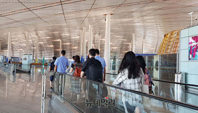 ▲ 박영학(앞쪽에서 걸어가는 남성) 큰샘 대표가 23일 오전 중국 베이징 서우두 국제공항에서 공안에게 억류됐다가 풀려났다. 박영학 대표 뒤로 푸른옷을 입은 공안들이 따라가고 있다. ⓒ뉴데일리 DB