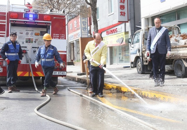 ▲ 류한우 단양군수(오른쪽 두번째)가 지난달 미세먼지 주의보가 내려지자 물차를 활용해 작업자들과 도로변 물청소를 하고 있다.ⓒ단양군