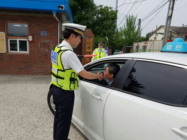 ▲ 경찰이 택시회사 앞에서 택시기사들을 상대로 음주 측정을 하고 있다.ⓒ충북경찰청