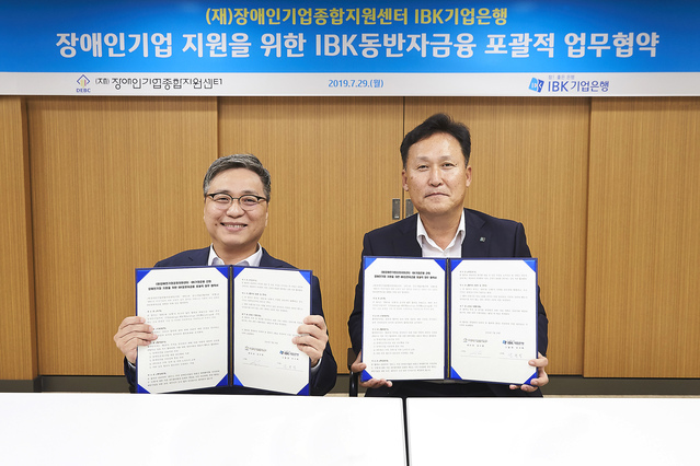 ▲ 지난 29일 기업은행 강서-제주 지역본부 회의실에서 전규백 기업은행 CIB그룹장(오른쪽)과 김수한 장애인기업종합지원센터 센터장이 협약식을 마치고 기념촬영을 하고 있다.ⓒ기업은행