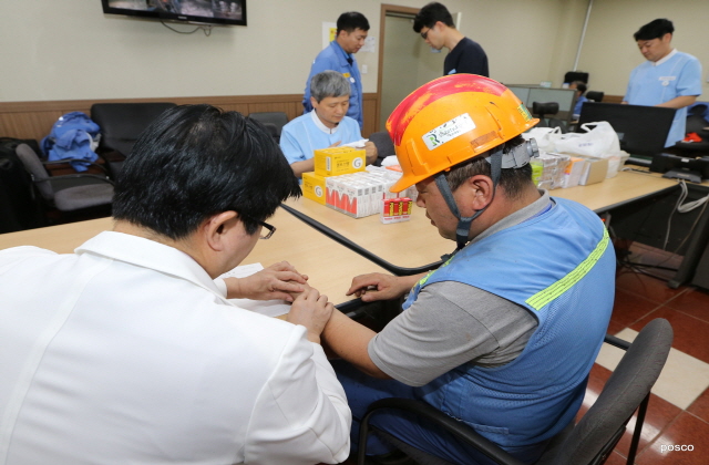 ▲ 포항제철소 2고로 방문진료에서 건강증진섹션 김창우 의사가 현장직원과 건강상담을 진행하고 있다.ⓒ포스코