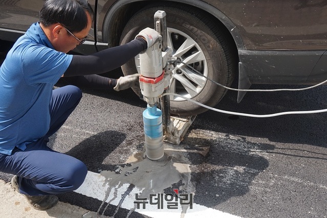 ▲ 아스콘 포장 정밀분석을 하기 위해 전문업체 관계자가 청주문화진흥재단 포장공사 현장에서 코아를 뜨고 있다.ⓒ김정원 기자