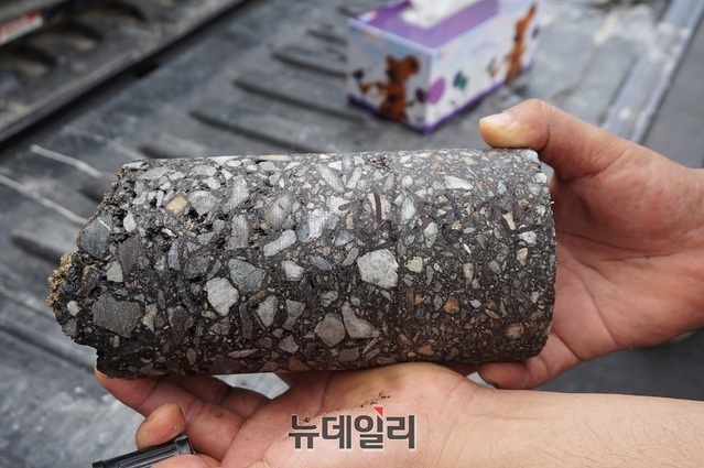 ▲ A 건설사가 장맛비가 내리는 가운데 도로포장으로 부실공사 우려가 나오고 있는 가운데 지난 1일 감리업체가 한국건설재료공학연구소에 의뢰해 아스콘 포장 정밀분석을 위해 코아를 떴다.ⓒ김정원 기자