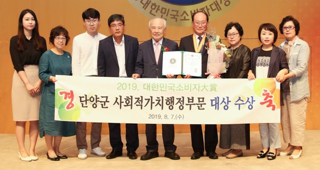 ▲ 지난 7일 류한우 단양군수(오른쪽 네번째)가 한국소비자협회가 주관한 '소비자 대상'을 받고 군과 구경시장 관계자들과 기념촬영을 하고 있다.ⓒ단양군